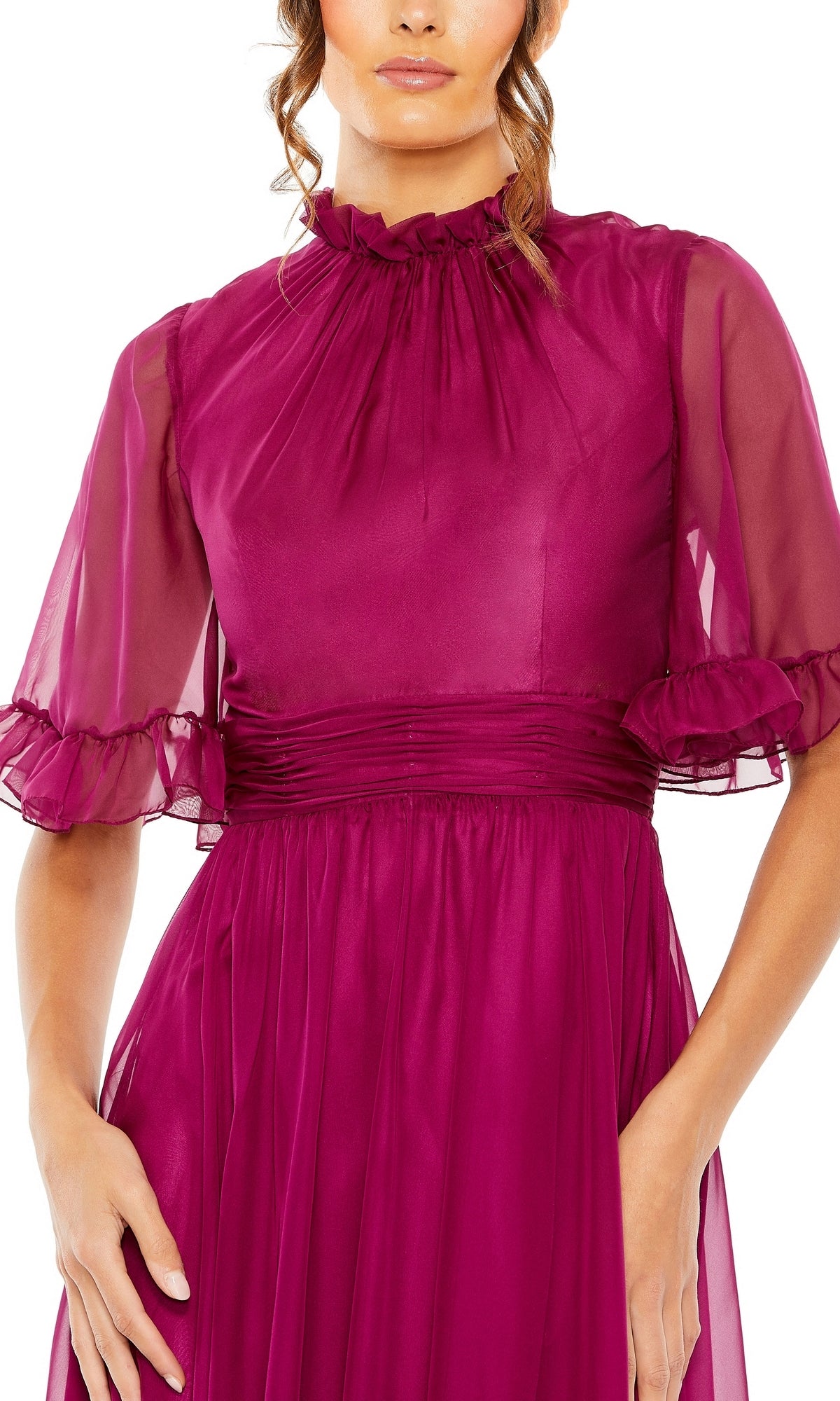 A woman wearing the Mac Duggal 68229 Short Sleeve Long Formal Dress in magenta, featuring a high neck, sheer sleeves, ruffled trim, and a gathered waist.